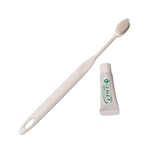 Natuur.in Daito transparent toothbrush with extra soft bristles and a small tube of toothpaste on a white background.