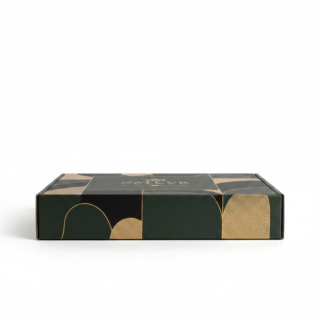Natuur.in luxury wellness gift box in forest green with elegant gold geometric accents on a white background.