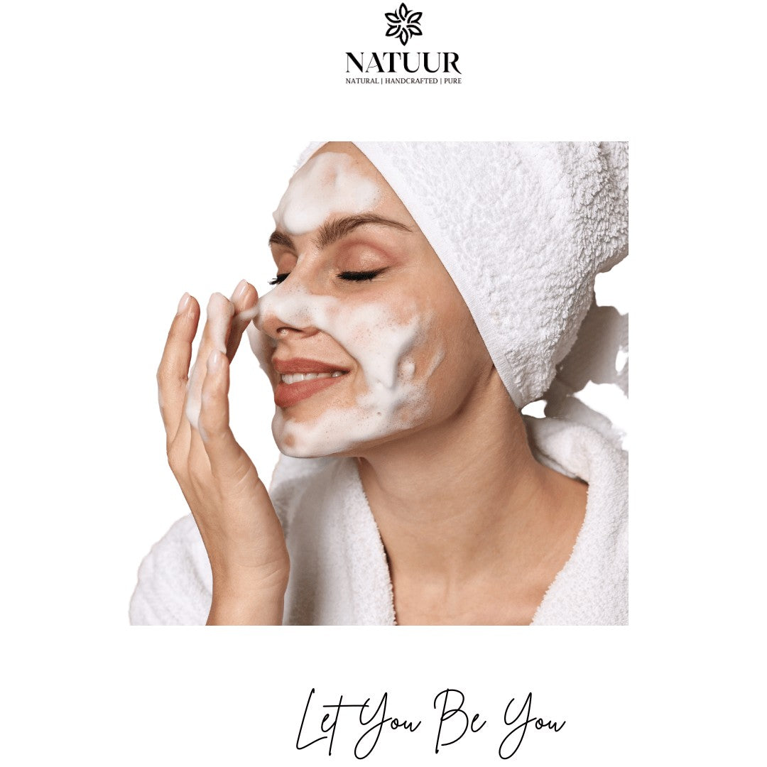 Woman with a white towel wrap applying Natuur.in Tea Tree Face Wash, showing rich white cleansing foam on her face.